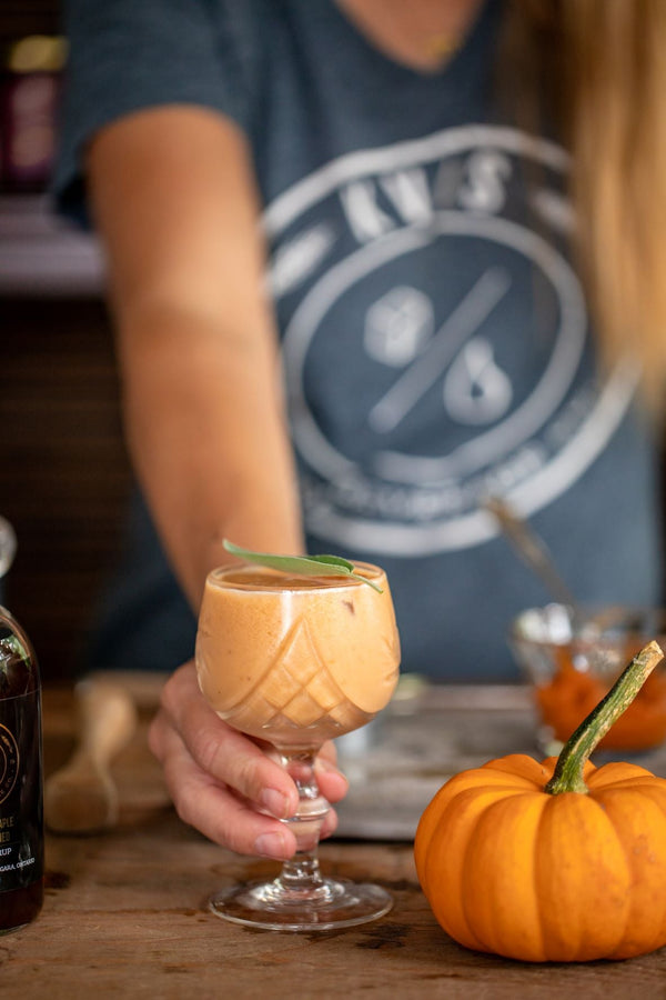 Person holding Old Fashioned Pumpkin Delight in cocktail glass made with Kvas Northern Maple Old Fashioned Simple Syrup