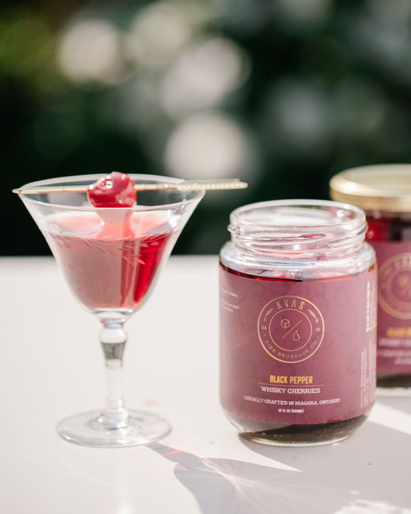 Cherry Boulevard cocktail beside Kvas Cherry Hibiscus Simple Syrup jar