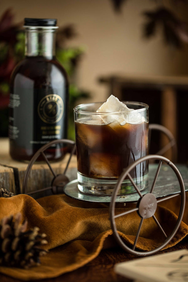 Closeup of Sunday Morning Old Fashioned cocktail with bottle of Kvas Old Fashioned Syrup